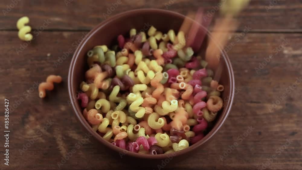 a lot of multicolored raw pasta is poured into a plate a lot of multicolored raw pasta is poured into a plate