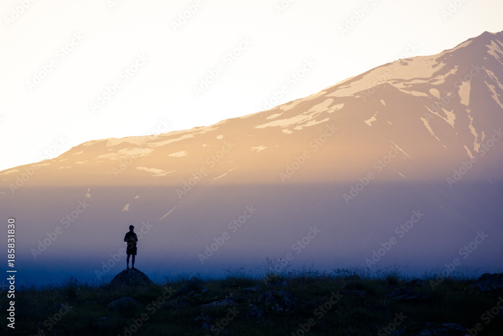 Sunlight and silhouette of a man on the background of the mountains