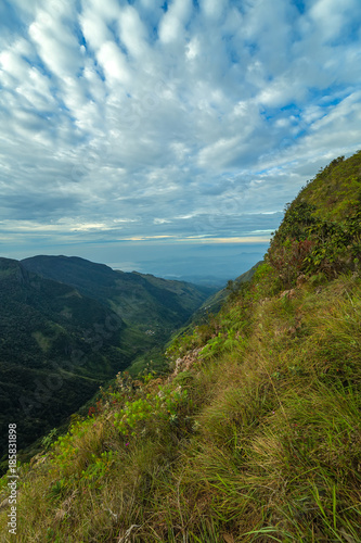 Sunrise in meadows and mountains landscape, Worlds End in Horton Plains National Park Sri Lanka.