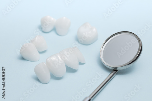 Dental mirror and dentures on a light blue background