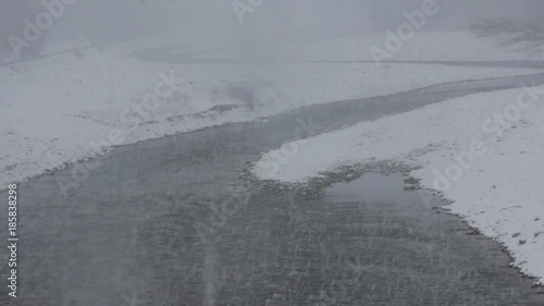 First snow, snow fog. Snow over mountain river. Shallows and shoals were drowned in snowy shroud, mask of snow, cohesionless snow, soft snoww, snow fell in large blotches
 photo