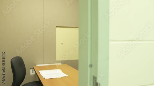 POV dolly movement shot entering a jail interview or interrogation room for criminal questioning by police. ProRes file, shot in 4K UHD.