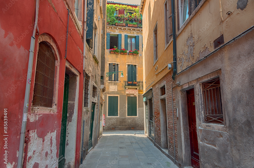 Beautiful venetian street with old houses in a sunny summer day.