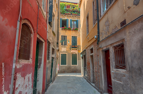 Beautiful venetian street with old houses in a sunny summer day.