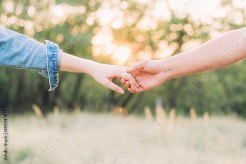 close-up of the hands of a guy and a girl who hold on to each other