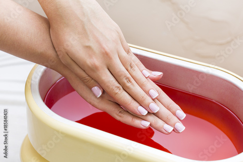 Process paraffin treatment of female hands in beauty salon