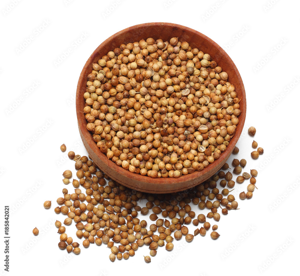 coriander seeds in wooden bowl isolated on white background top view