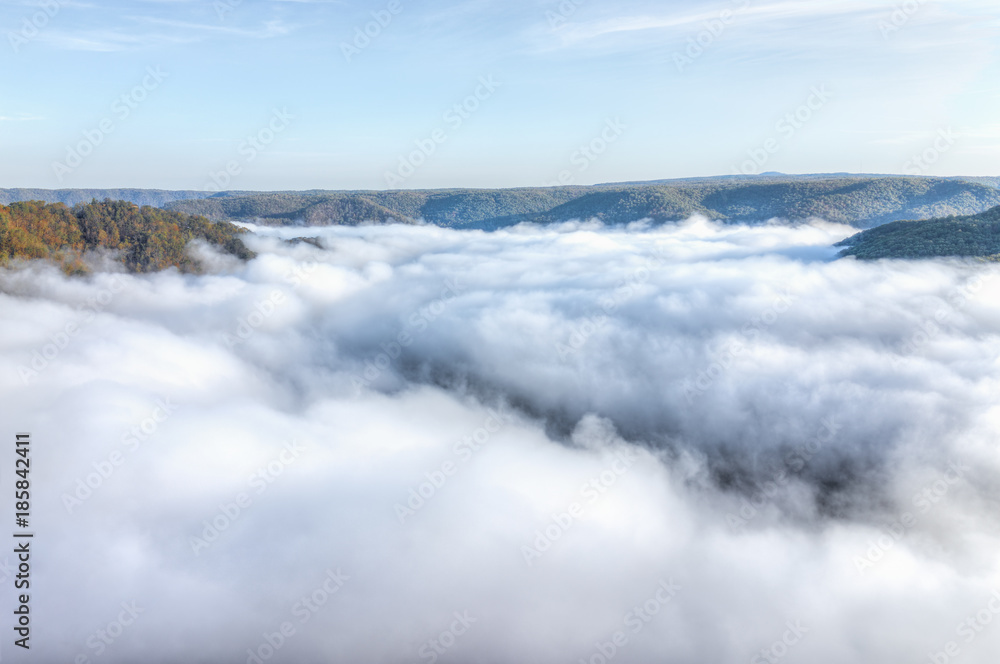 Mountains and fog, mist clouds in morning floating above forest trees, covering, blanketing valley in Grandview Overlook, West Virginia