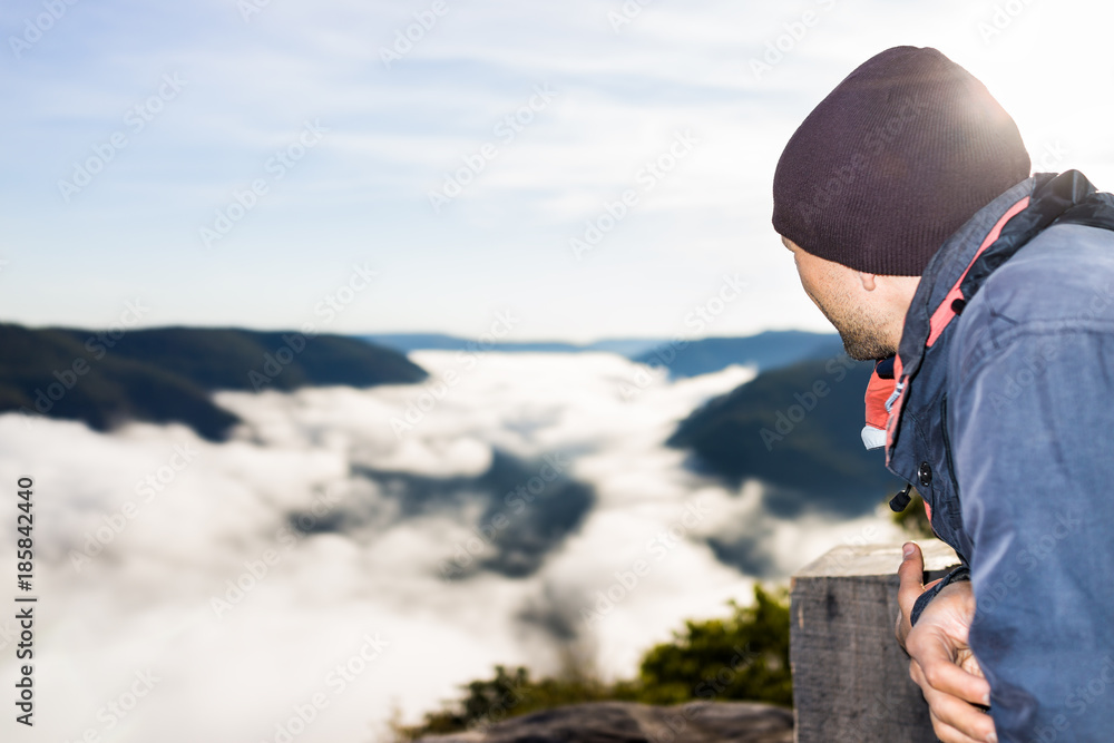 Closeup of man by mountains and fog clouds covering valley in morning sunrise in Grandview Overlook, West Virginia looking at view Closeup of man by mountains and fog clouds covering valley in morning sunrise in Grandview Overlook, West Virginia looking at view