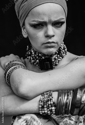 beauty bright african woman with creative make up, shawl on head like cubian closeup photo