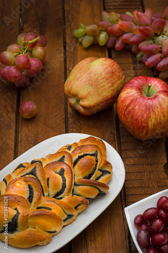 Still life of homemade pastries, sweet poppy pie on the background of fresh fruits, apples and grapes