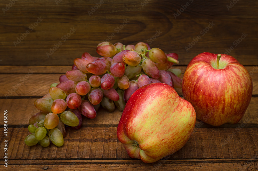 Apples and grapes on a wooden rustic background. Still life for thanksgiving with autumn fruits. Selective focus. Top view Apples and grapes on a wooden rustic background. Still life for thanksgiving with autumn fruits. Selective focus. Top view