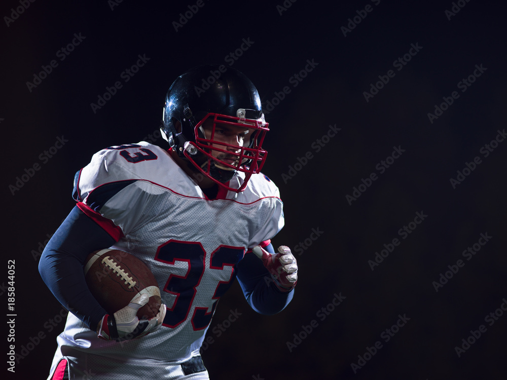 American football player holding ball while running on field