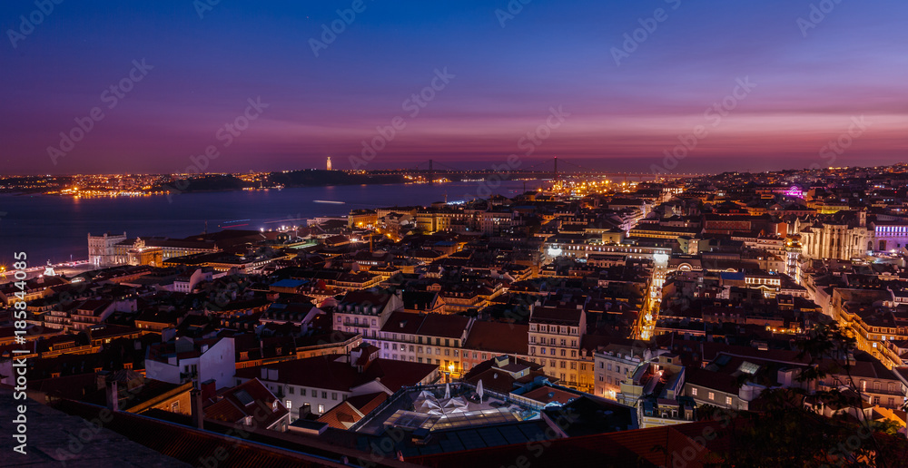 Breathtaking establishing shot of Lisbon, Portugal at dusk overseeing the entire downtown, the Tagus river, the Cristo Rei and the Ponte 25 de Abril suspension bridge.