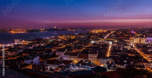 Breathtaking establishing shot of Lisbon, Portugal at dusk overseeing the entire downtown, the Tagus river, the Cristo Rei and the Ponte 25 de Abril suspension bridge.