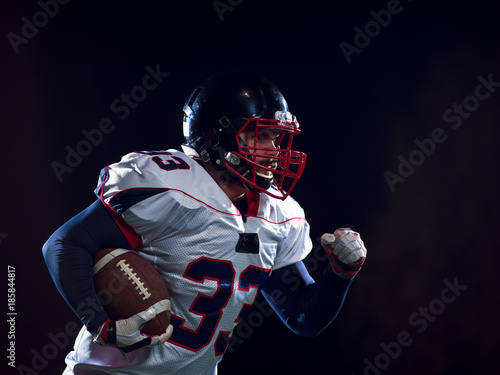American football player holding ball while running on field