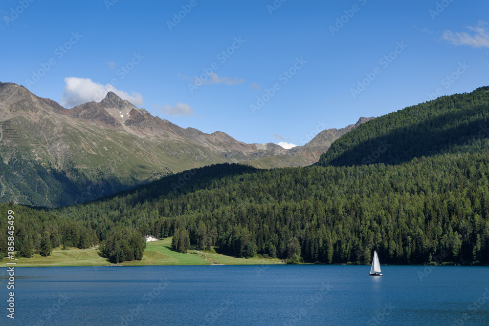beautiful summer panorama of Lake St.Moritz with one white sailboat on the water