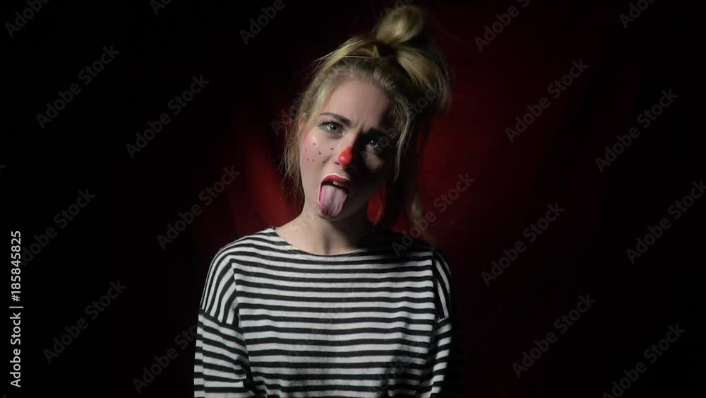 Funny blonde clown sticks out her tongue and waves her hands Funny blonde clown sticks out her tongue and waves her hands