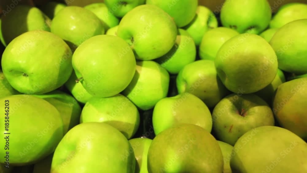Panoramic shooting of fresh juicy green apples in a plastic container in a supermarket. Closeup shot. Panoramic shooting of fresh juicy green apples in a plastic container in a supermarket. Closeup shot.