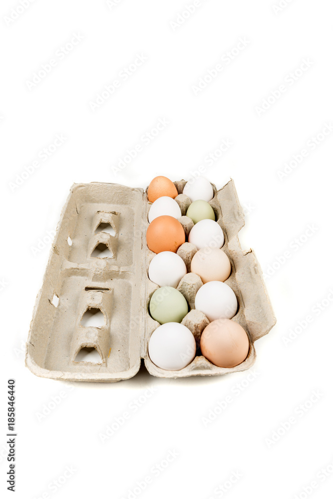 Farm fresh and commercial eggs in a carton on a white background Farm fresh and commercial eggs in a carton on a white background