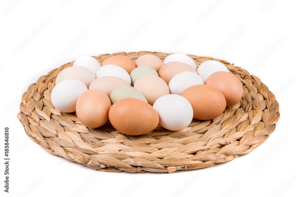 Farm fresh and commerical eggs on a woven mat Farm fresh and commerical eggs on a woven mat