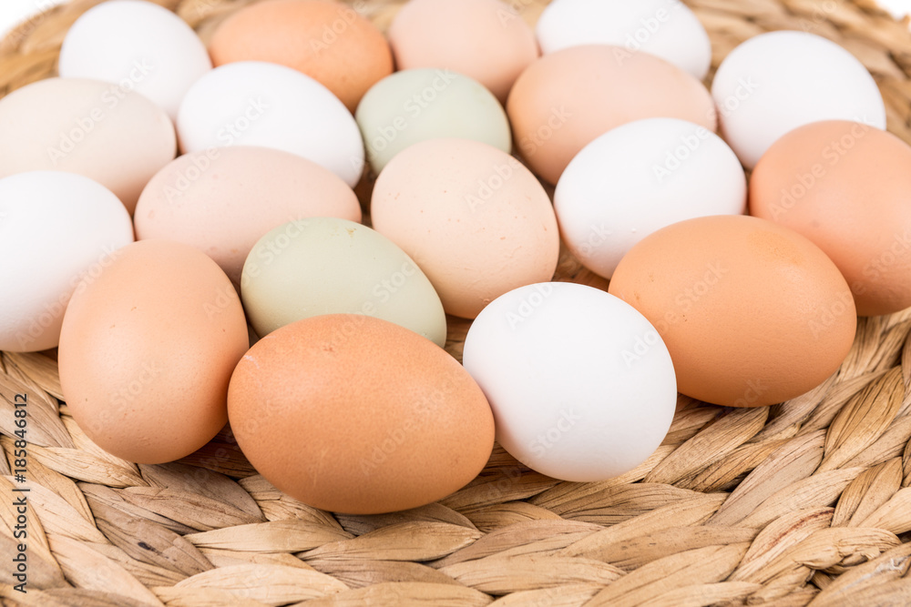 Farm fresh and commerical eggs on a woven mat Farm fresh and commerical eggs on a woven mat