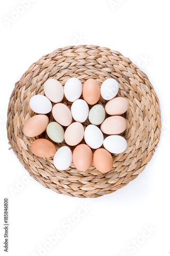 Farm fresh and commerical eggs on a woven mat photo