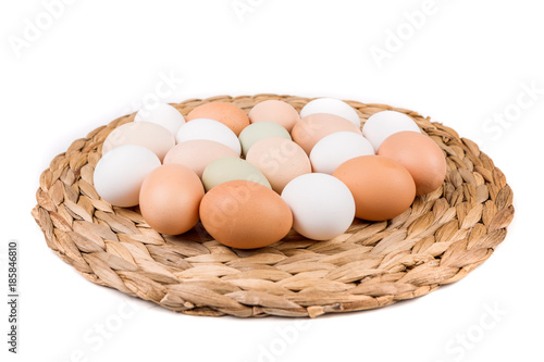 Farm fresh and commerical eggs on a woven mat