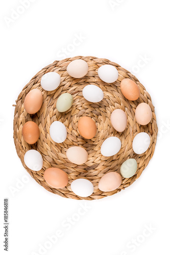 Farm fresh and commerical eggs on a woven mat photo