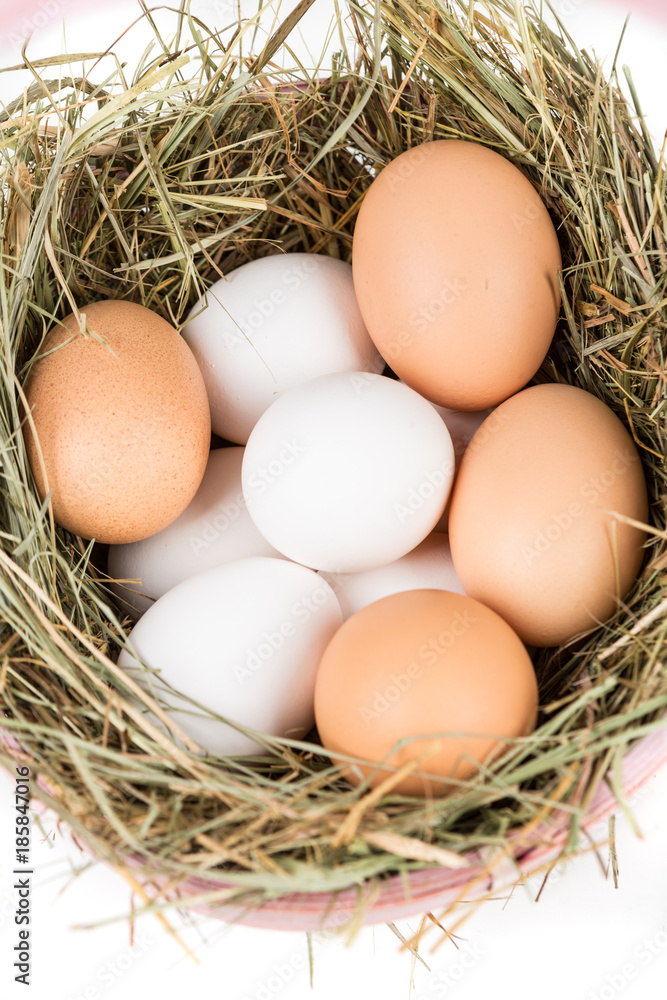 Easter basket filled with fresh and commercial eggs and hay Easter basket filled with fresh and commercial eggs and hay