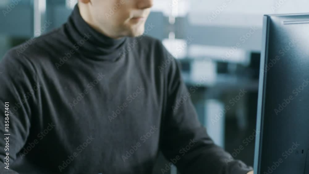 Young Male Industrial Engineer Works on a Personal Computer. Handsome Smart Man in the Bright Modern Office.Shot on RED EPIC-W 8K Helium Cinema Camera.