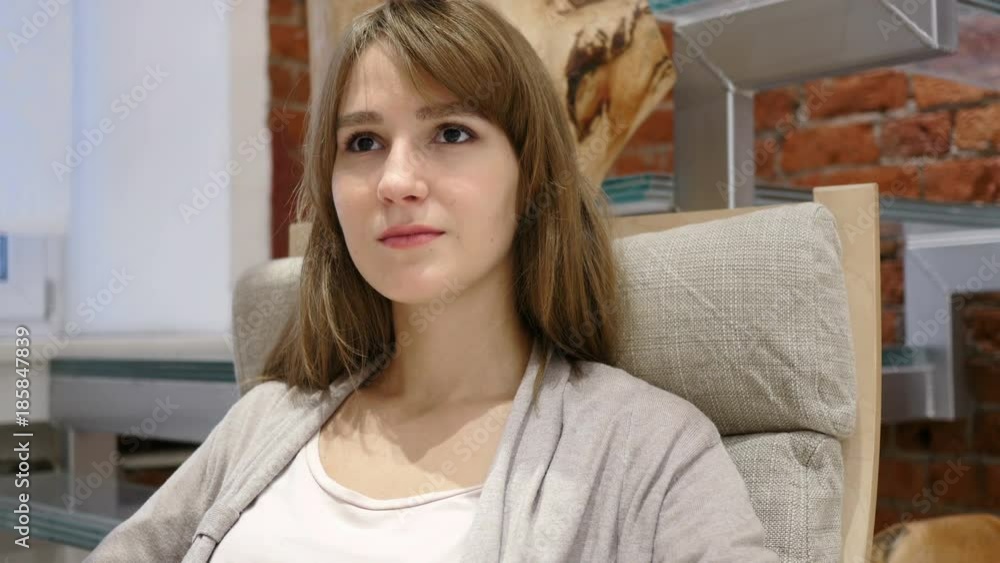 Portrait of Serious Young Woman Sitting on Relaxing Chair Portrait of Serious Young Woman Sitting on Relaxing Chair