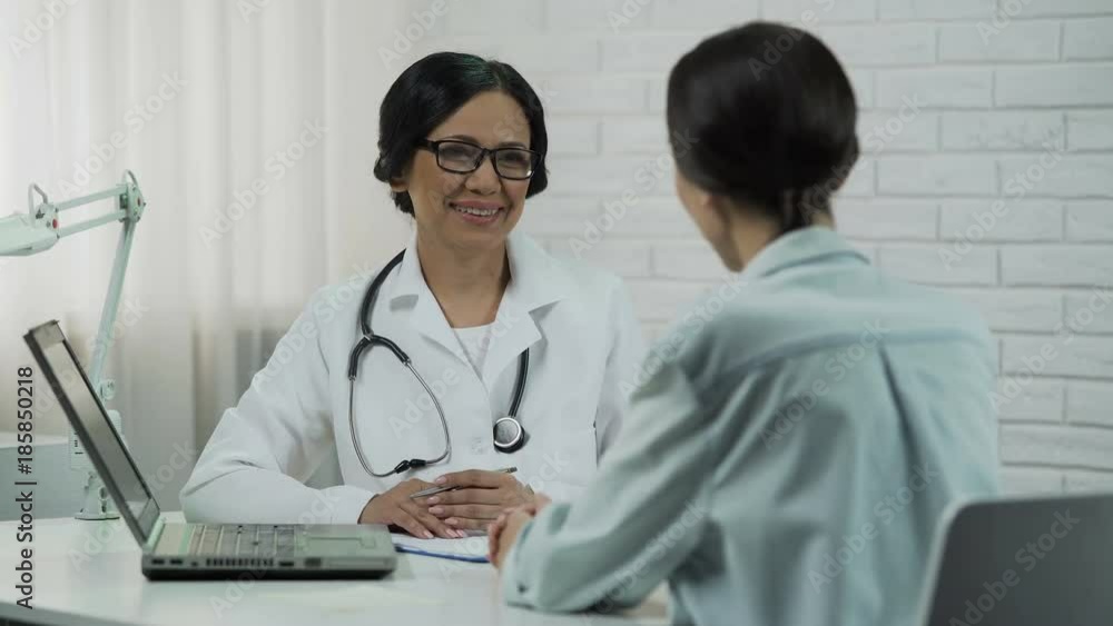 Doctor showing test results on laptop, effective treatment, patient recovering Doctor showing test results on laptop, effective treatment, patient recovering