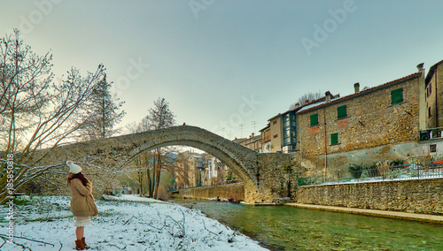 woman near bridge with donkey back photo