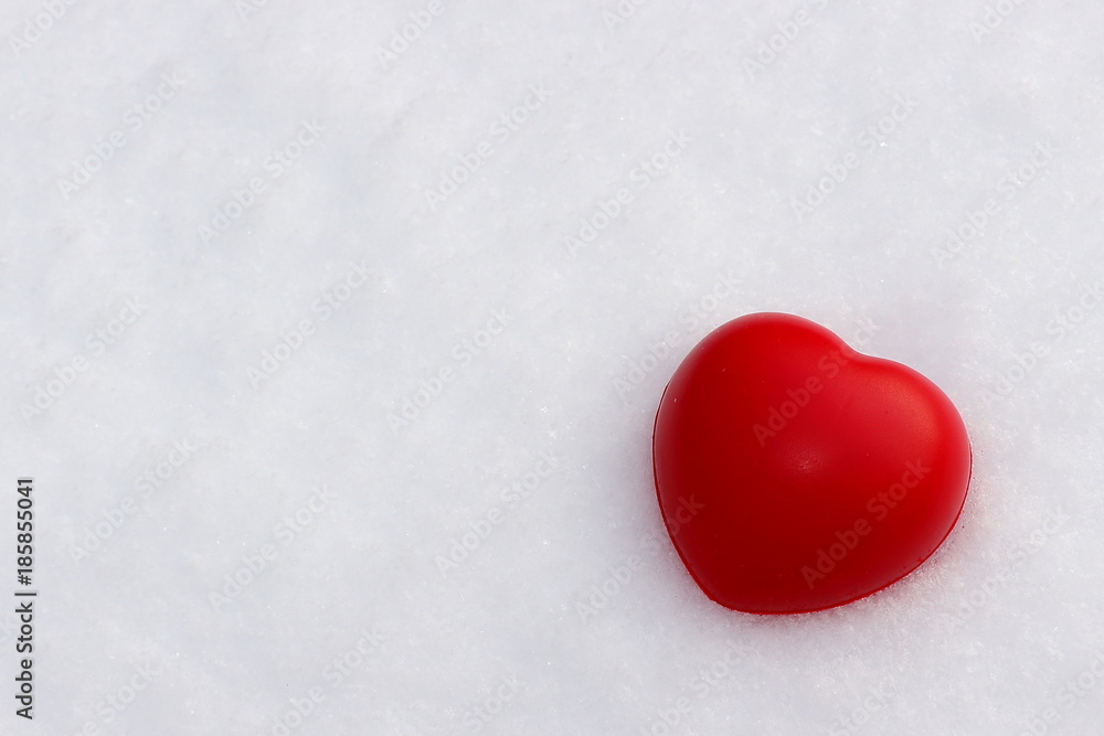 Background for Valentine's Day with a red heart on fluffy white snow with copy space Background for Valentine's Day with a red heart on fluffy white snow with copy space