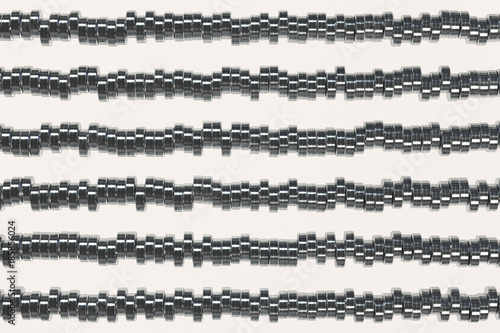 Pattern of brushed metal cylinder tablets on white background
