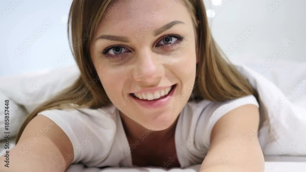 Beautiful Woman Lying in Bed Smiling and Looking in Camera Beautiful Woman Lying in Bed Smiling and Looking in Camera