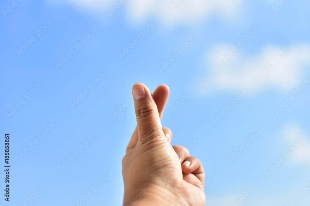 finger sign mini heart on blue sky and cloud. subject is blurred. finger sign mini heart on blue sky and cloud. subject is blurred.