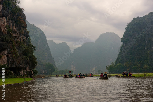 Row boats on a river under cast sky in Vietnam © Cinar
