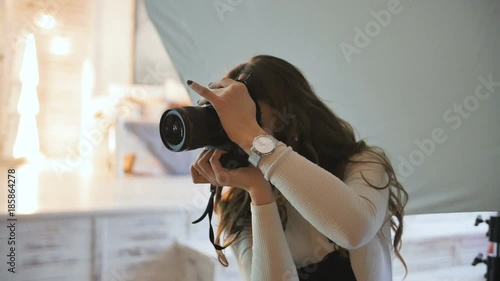 Young beautiful photographer with the professional camera. Shooting, laughing and having fun. Smile