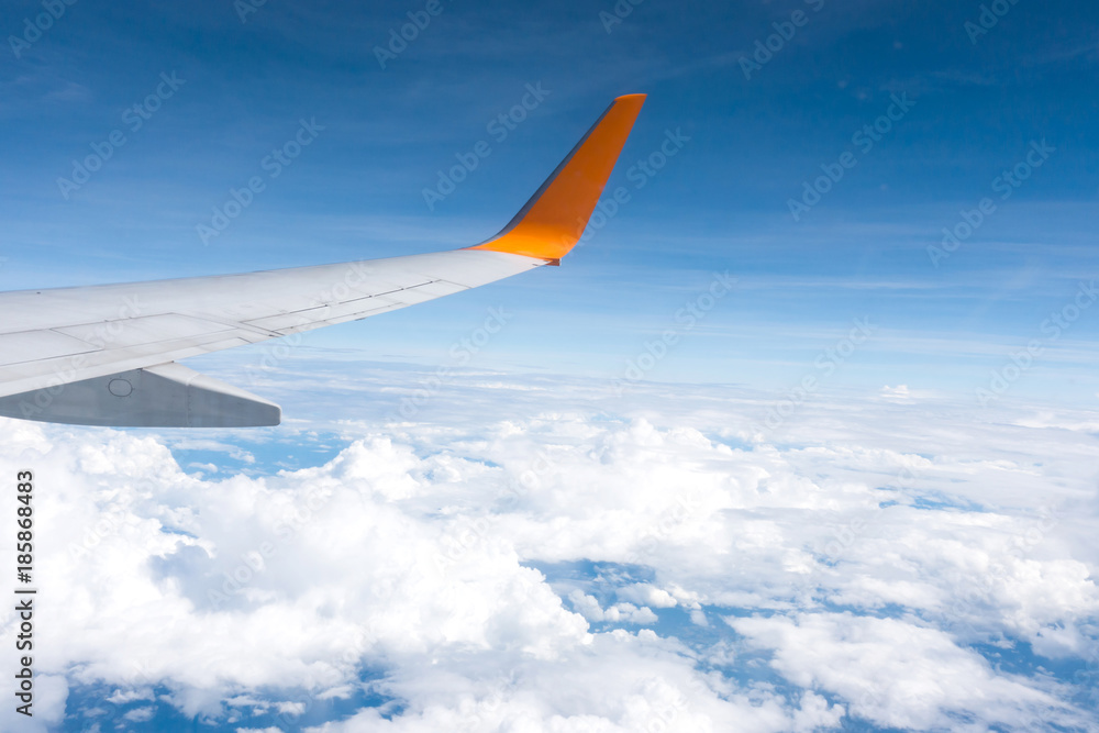 Obraz premium Wing of an airplane flying above the clouds 