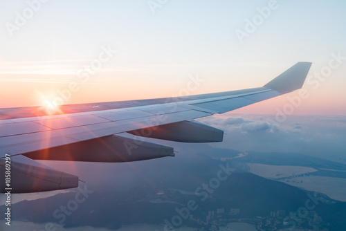 Wing of an airplane with Morning sunrise. Photo applied to tourism operators. picture for add text message or frame website. Traveling concept.