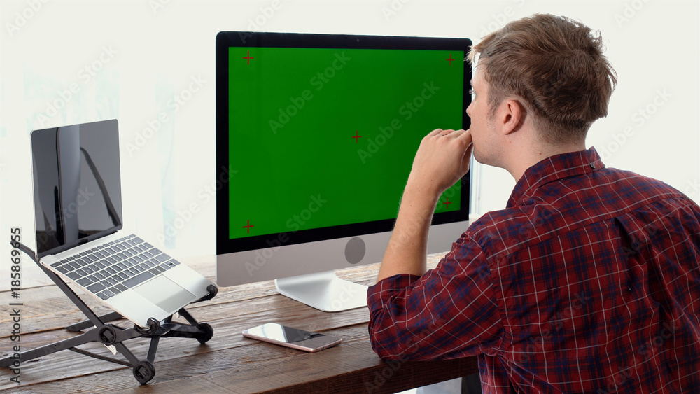 Young freelancer thinking during working with green screen display Young freelancer thinking during working with green screen display