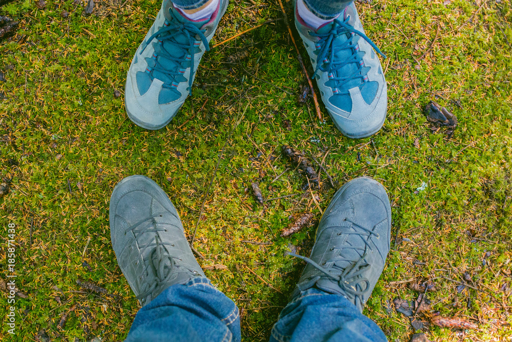 Pair of Man and woman feet in love Romantic Outdoor with moss on the background life-Style Fashion concept. Tourists. Hiking shoes