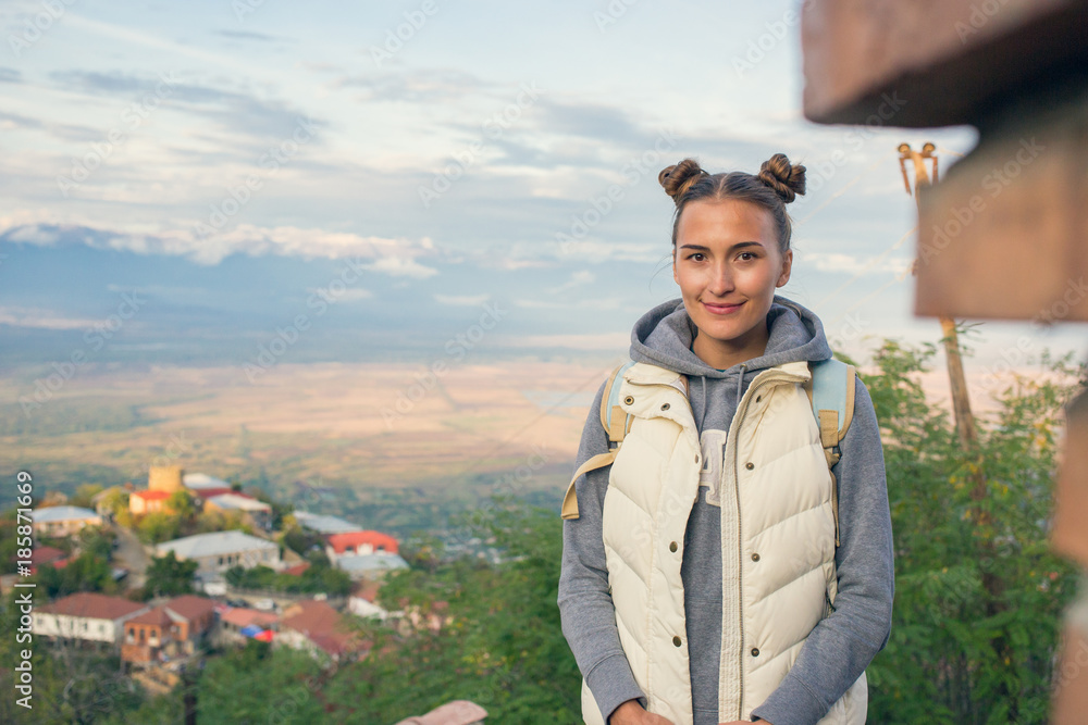 So a beautiful woman is standing on top of a mountain with a backpack. Behind Alazani valley, Georgia. Sunset. Beautiful panorama. Cohete. Sighnaghi. Kontrazhur So a beautiful woman is standing on top of a mountain with a backpack. Behind Alazani valley, Georgia. Sunset. Beautiful panorama. Cohete. Sighnaghi. Kontrazhur