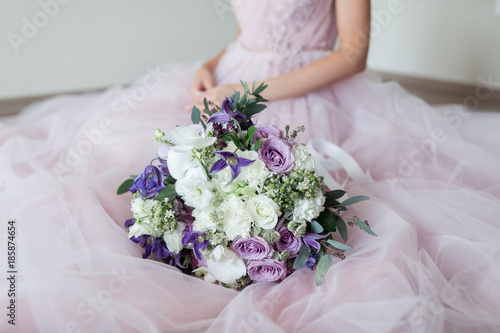 beautiful wedding bouquet with different flowers on bride's hands.