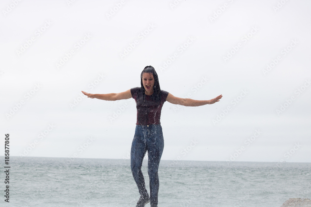 Obraz premium San francisco beach waves water and fun you must visit during your vacation in America teen girl gets wet by the waves
