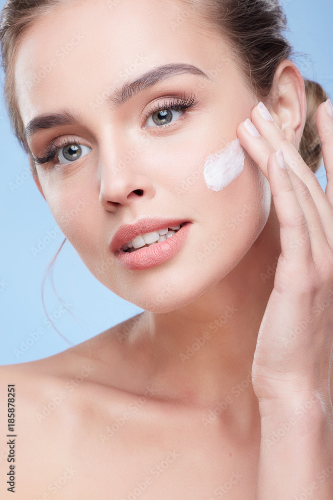 Young woman applying cream