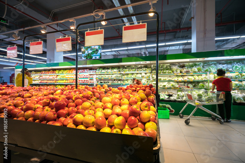 Fresh red apples on shelf in supermarket.