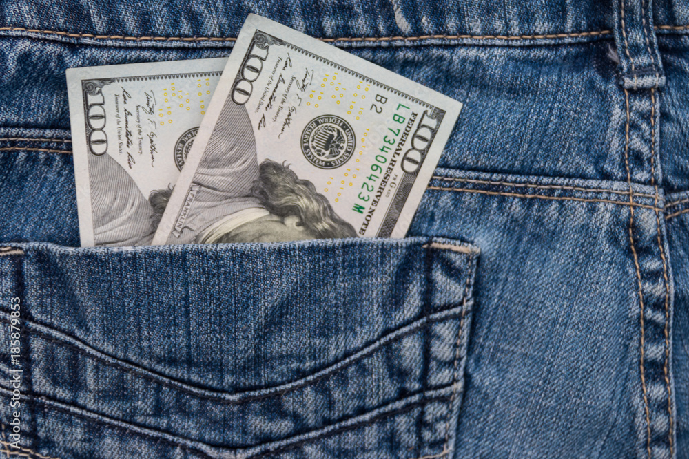 One hundred American dollars bills in the pocket of blue jeans One hundred American dollars bills in the pocket of blue jeans
